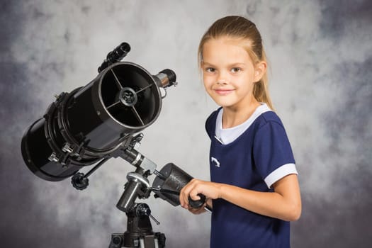 Seven-year girl adjusts the telescope and looked into the frame