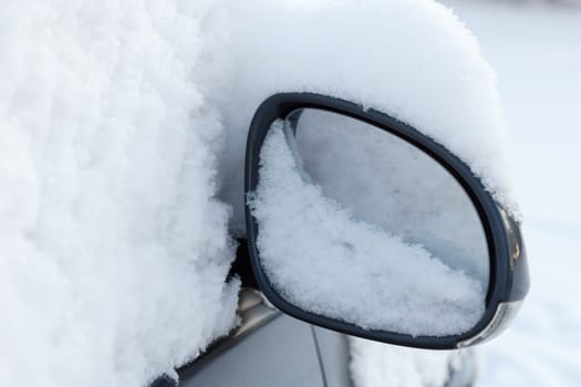 car mirror fully covered with fresh snow