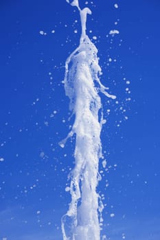 Water stream splashing on blue sky background