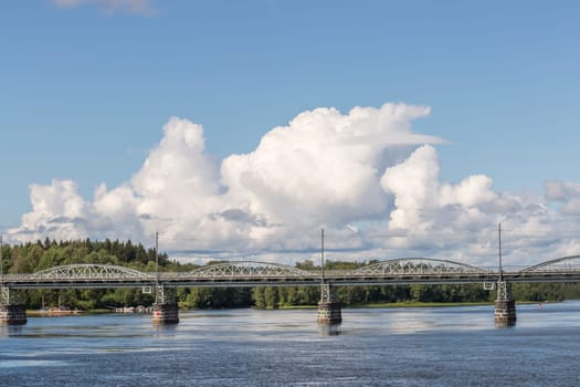 Bridge over River in Umea, Sweden with a partly cloudy sky.