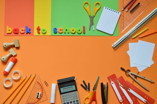 School supplies on colorful paperboard and the words BACK TO SCHOOL
