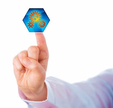 Cutout of a male white collar worker hand with raised index finger touching a hexagonal virtual push button displaying three interlocking cog wheels. Business metaphor for process automation.