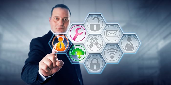 Confident business director is activating three managed services icons by touch on a control screen. The remaining six of nine IT buttons remain gray. Concept for efficiency through managed services.