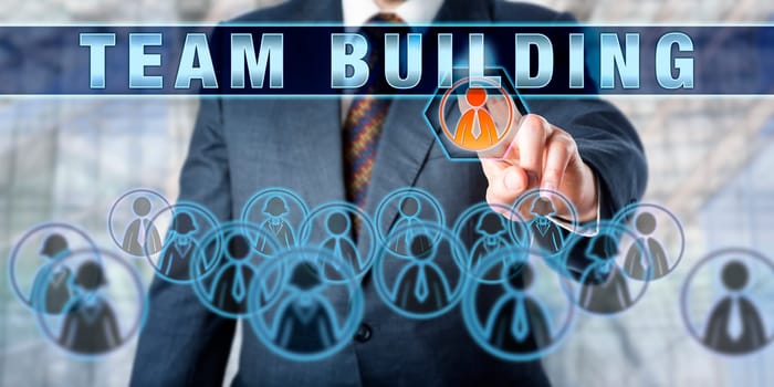 Corporate manager is pressing TEAM BUILDING on a virtual control monitor. Business concept for managing team-based working relationships and the impact of globalization trends on virtual workplaces.