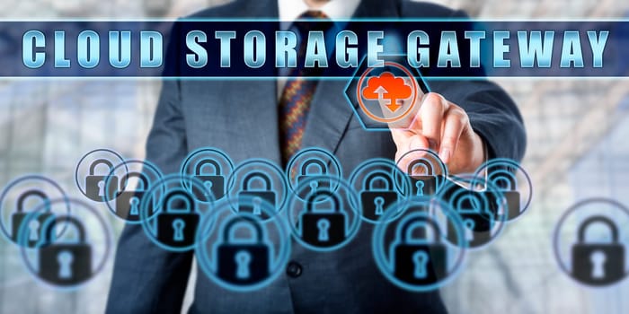 Corporate manager is pushing CLOUD STORAGE GATEWAY on a virtual control monitor. Business metaphor. Emerging technologies concept involving cloud storage, encryption and data security.