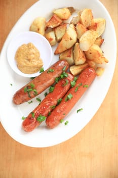 Home-fried potatoes and sausages with scallions and mustard, copy space at bottom