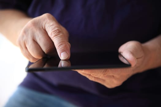 A man searches the internet on his tablet.