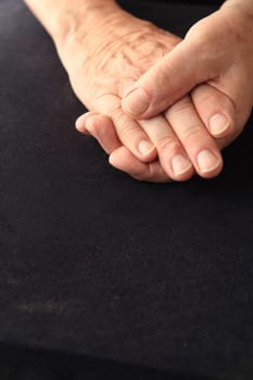 Senior man grasps his aching fingers, copy space included