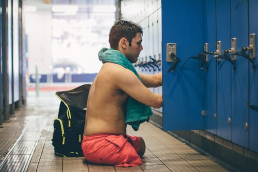 Quadriplegic athlete getting his belongings from the swimming locker.