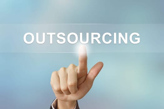business hand pushing outsourcing button on blurred background