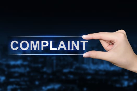 hand pushing complaint button on blurred blue background