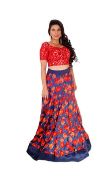 A beautiful East Indian woman in a long blue and red skirt and red top.standing isolated for white background..