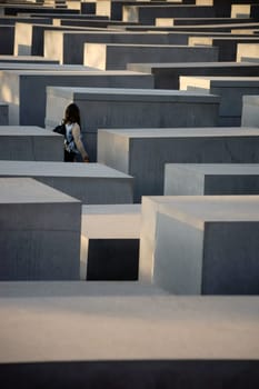 Berlin,Germany - May 10,2016: A tourist stands between the grey concrete blocks of the Memorial to the Murdered Jews of Europe on May 10,2016 in Berlin.