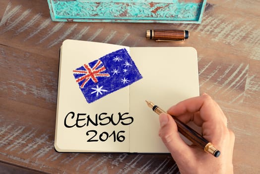 Retro effect and toned image of a woman hand drawing the Australian Flag with a fountain pen on a notebook. Concept image with CENSUS 2016 and Australian flag