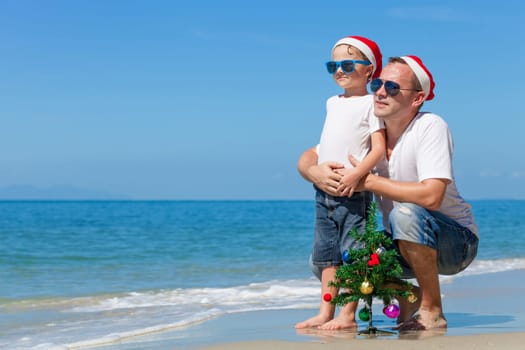 Father and son playing on the beach at the day time. Concept of Happy New Year.