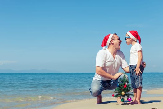Father and son playing on the beach at the day time. Concept of Happy New Year.