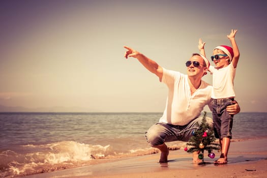Father and son playing on the beach at the day time. Concept of Happy New Year.