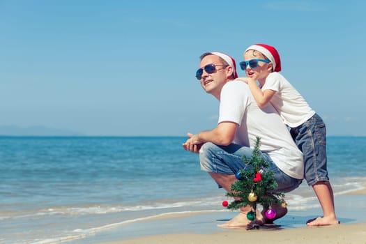 Father and son playing on the beach at the day time. Concept of Happy New Year.