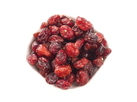 Dried cranberries in a white bowl on a white background top view