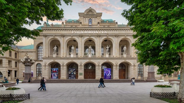 Ganja, Azerbaijan - May 13 2024: Ganja State Philharmonic Hall, renowned for its stunning architecture and cultural performances, features a classical facade adorned with arches, columns, and statues