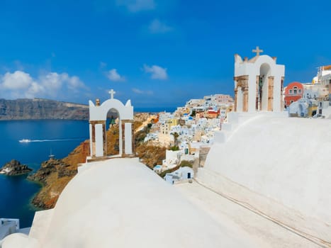 Oia, Greece - June 10, 2015: Santorini - The beautiful white bell tower on the sea in the background. Beautiful sea view on Santorini island, Oia, Greece.
