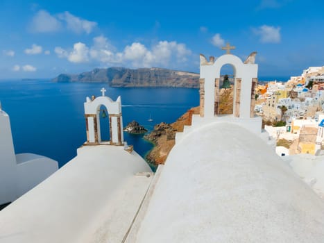 Oia, Greece - June 10, 2015: Santorini - The beautiful white bell tower on the sea in the background. Beautiful sea view on Santorini island, Oia, Greece.