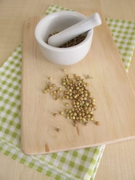 Coriander seeds and a mortar