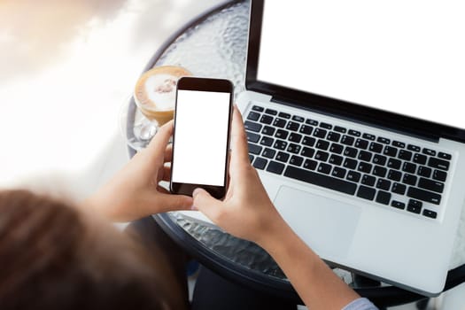 woman using phone on work table in coffee shop