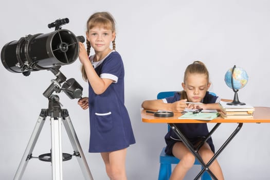 Girl watches in the telescope, the other girl is waiting for the results of observations