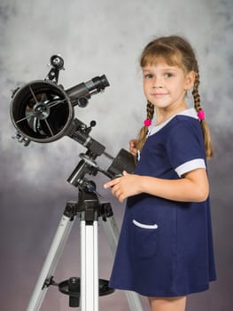 Girl lover of astronomy stands next to the telescope and looked into the frame