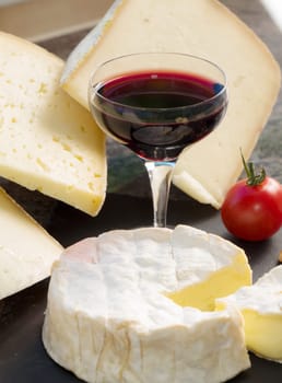 a camembert cheese with a glass of wine