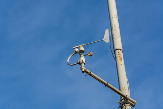 Weather station with anemometer on blue sky..