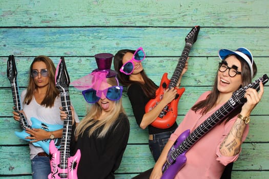 Party with photo box - girls pose with guitars in front of Photobooth