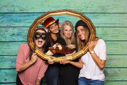Young women look through a photo frame - Fotobox Party