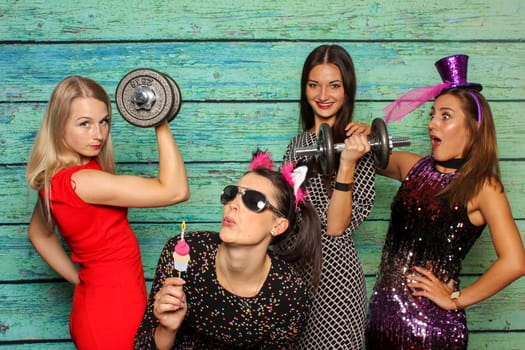 Young girls with dumbbells in front of photo box