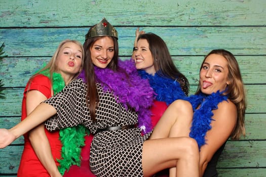 Young girls silly around in front of a photo box