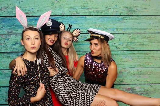 Cute girls with headgear in front of a photo box