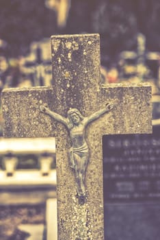 close up on cross of jesus christ on cemetery. vintage effect