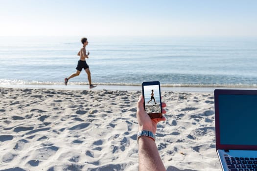 A businessman photographing a guy at the beach on vacation.
