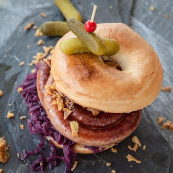 Grilled bratwurst in a broetchen with red cabbage and roestz onions
