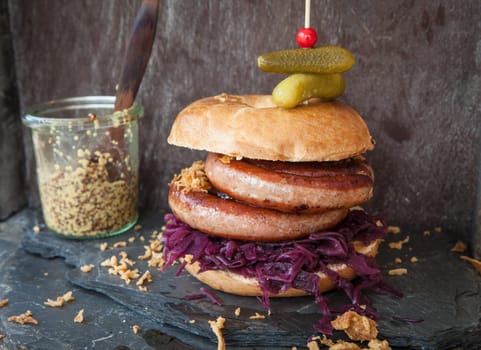 Grilled bratwurst in a broetchen with red cabbage and roestz onions
