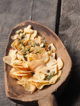 Old wooden spoon with Italian cooking ingredients on a rustic wooden table, close up shot with selective focus