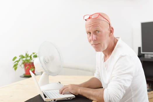a mature man with a laptop in the house