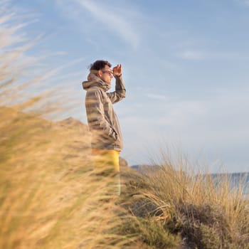 Sporty active man looking at distance, enjoying beautiful nature, freedom and life at serene landscape at Balos beach. Active lifestyle outdoors.