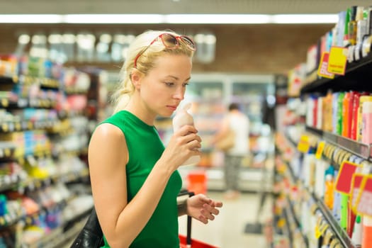 Beautiful caucasian woman shopping personal hygiene products at supermarket.
