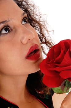 A closeup image of a beautiful young woman holding a red rose close.to her face, isolated for white background..