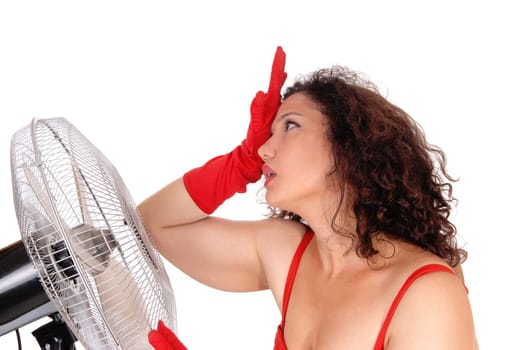 A young woman standing very hot in the heat in front so a big fan to.get some help from the heat, isolated for white background..
