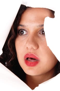 .A lovely woman looking through a hole in a paper, is shocked what she .see's, isolated for white background..