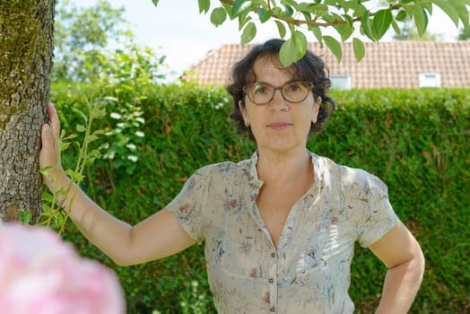 a mature woman with glasses in the garden