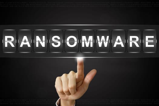 business hand pushing ransomware on Flipboard Display